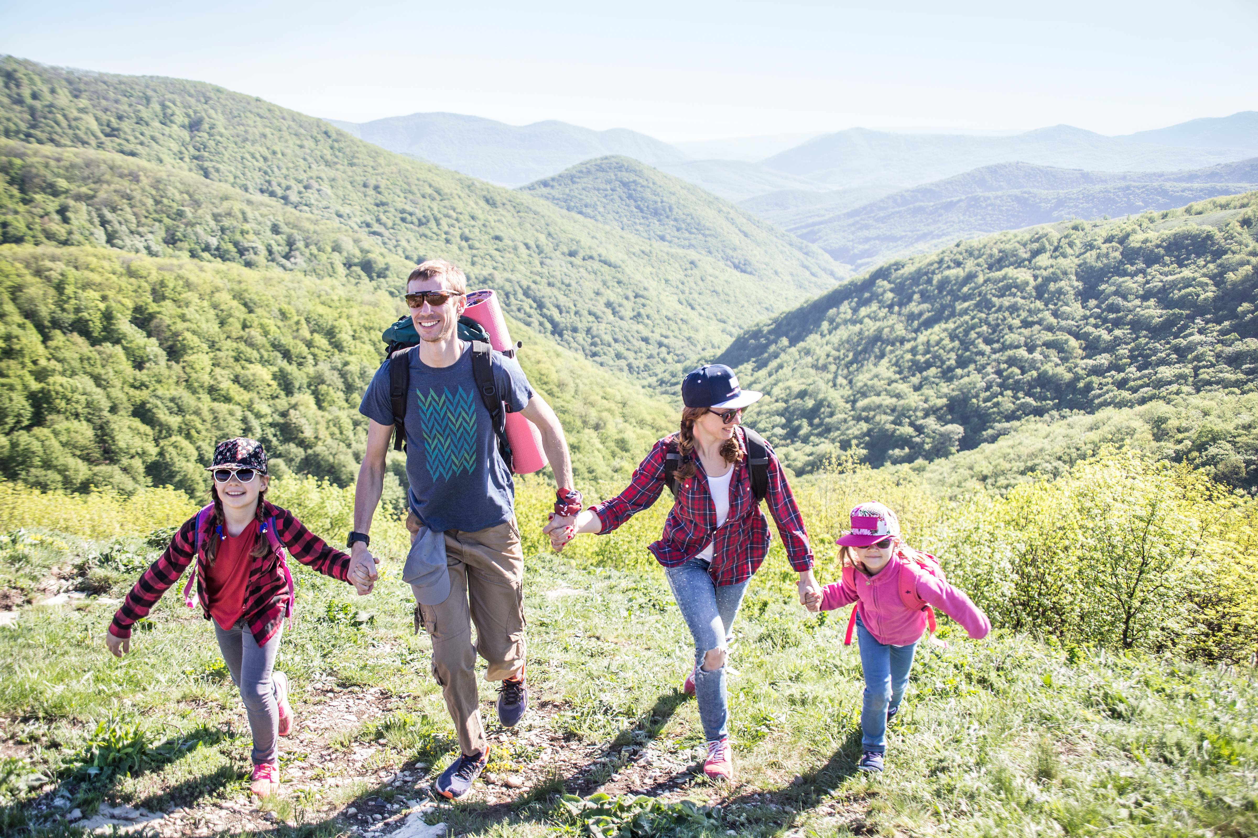 family with two kids have hiking  through the mountains